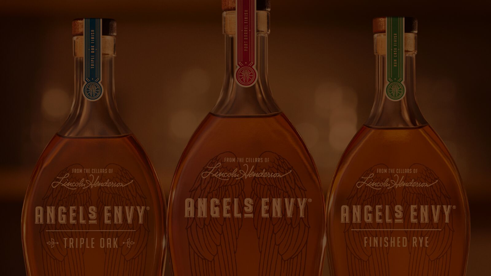 A darkened, label focused shot of the top half of the three Angel’s Envy Signature Series expressions.