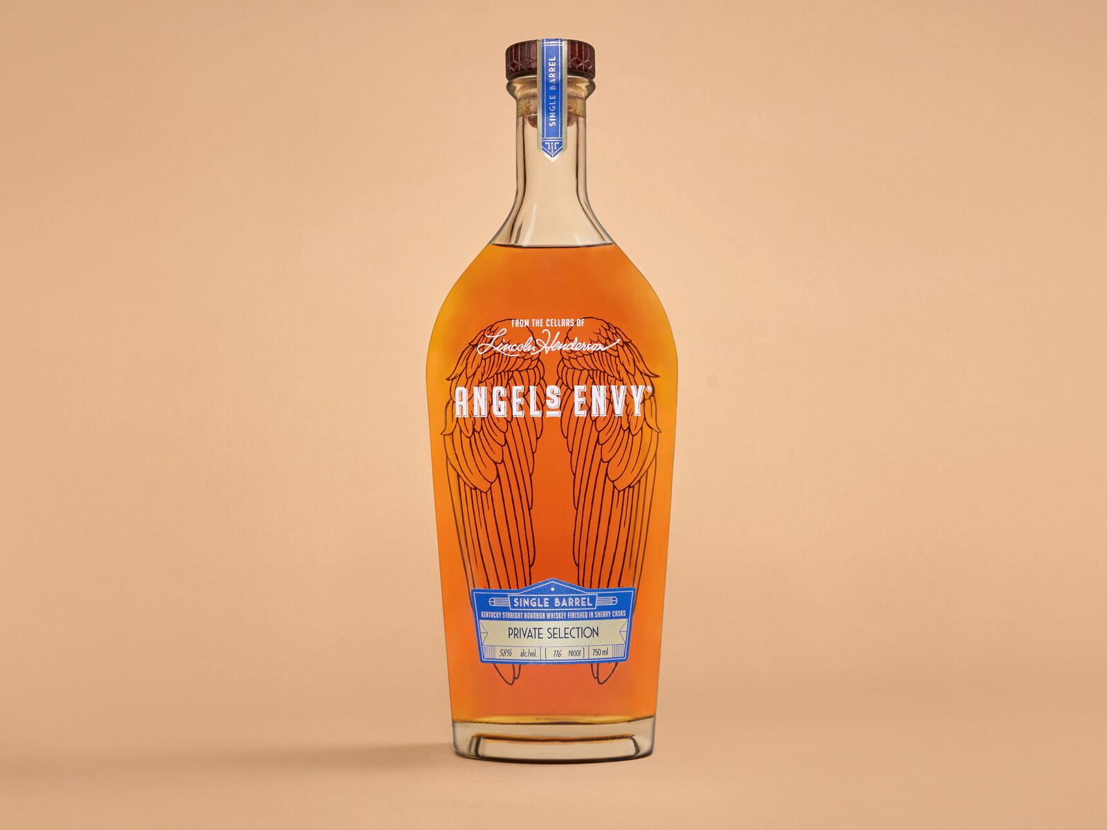 A bottle of the Angel’s Envy Single Barrel Bourbon Finished in Oloroso Sherry Wine Barrels staged on a soft orange background.