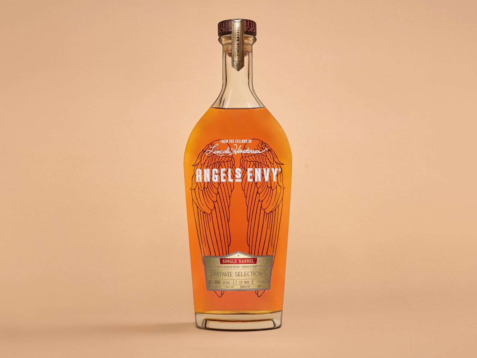 A bottle of the Angel’s Envy Single Barrel Bourbon Finished in Tawny Port Wine Barrels staged on a soft orange background.
