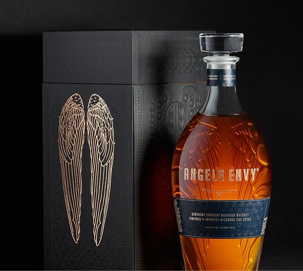 The bold, black-detailed Angel’s Envy Mizunara Finished Bourbon in front of it’s black presentation box featuring a patent golden wings logo.