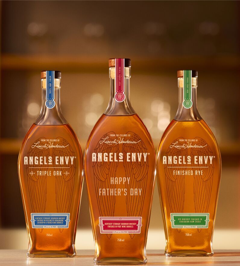 The three Signature Series expressions being warmly presented on bar in the Angel’s Envy Distillery with contemporary light fixtures in the background.