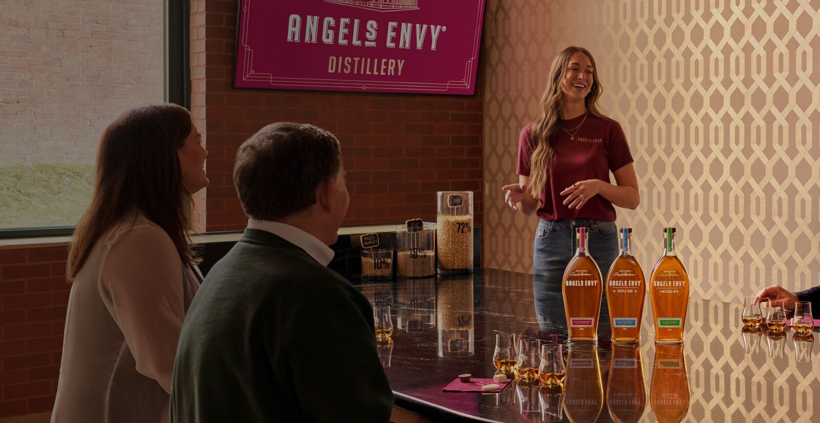 Set inside the Angel’s Envy Distillery in Louisville, Kentucky, a group of people sit attentively around a table and listen to a guide tasting experience.