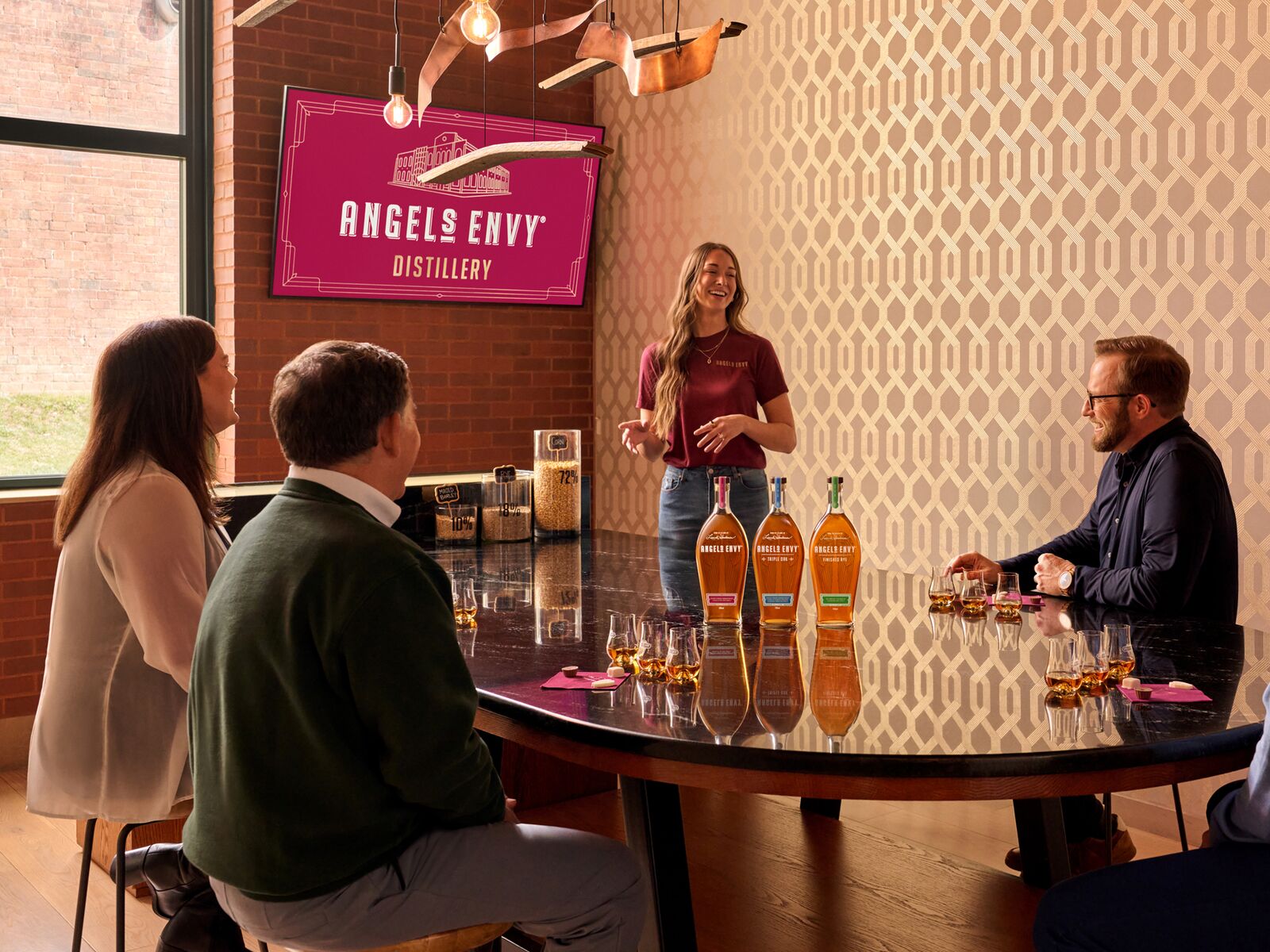Set inside the Angel’s Envy Distillery in Louisville, Kentucky, a group of people sit attentively around a table and listen to a guide tasting experience.
