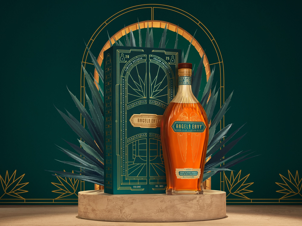 Angel’s Envy Cellar Collection Rye displayed beside its decorative green presentation box against a dark green botanical backdrop made with agave.