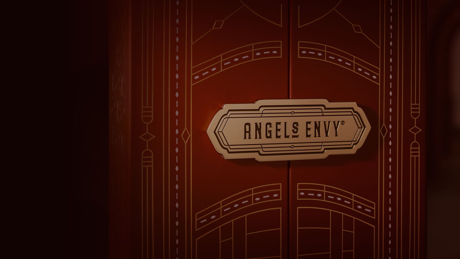The Angel’s Envy logo embossed on a golden plaque that is sealing a decorative Angel’s Envy presentation box shut.